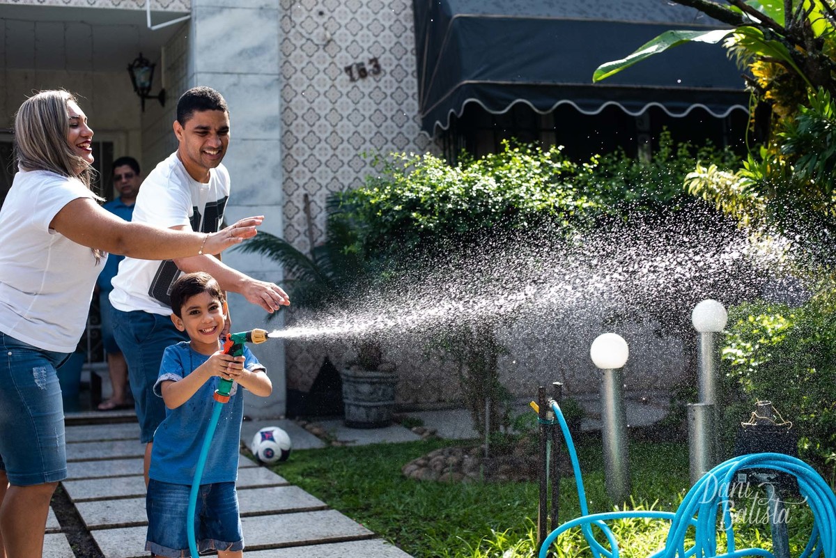 familia brincando com agua durante ensaio fotografico em casa