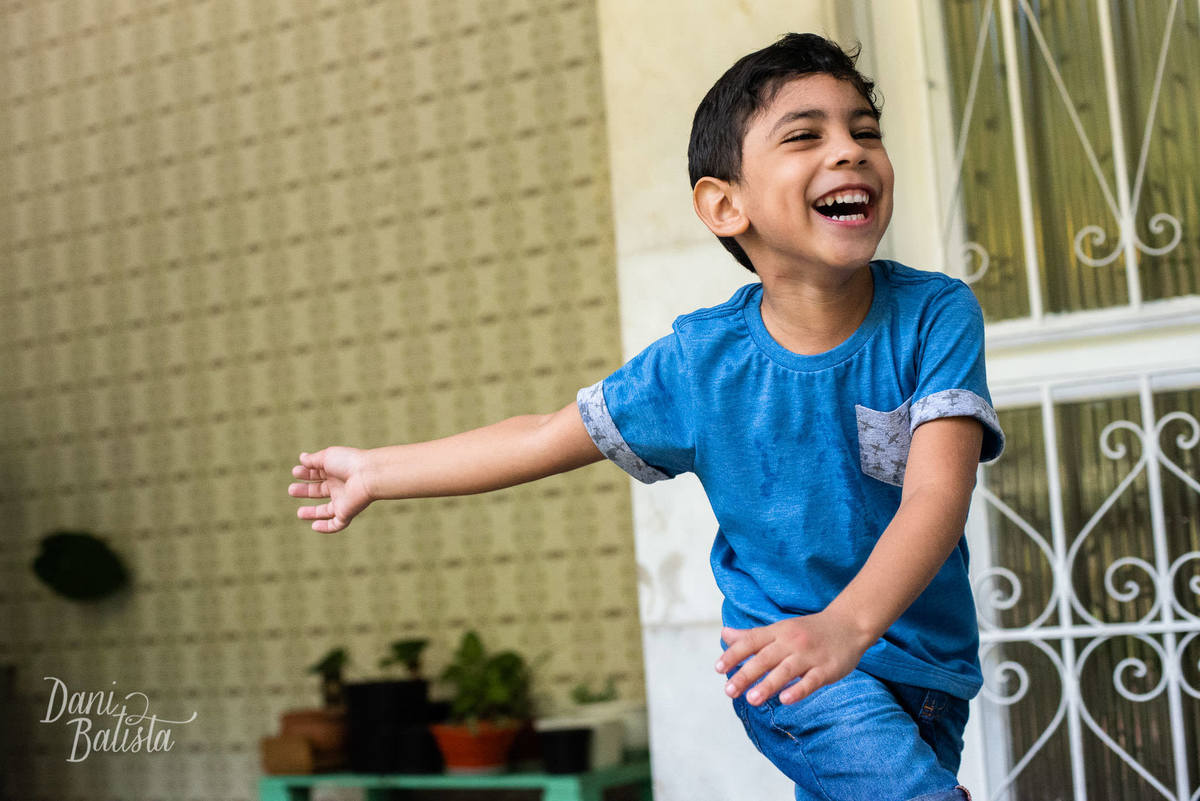 criança correndo durante ensaio fotografico de familia em casa