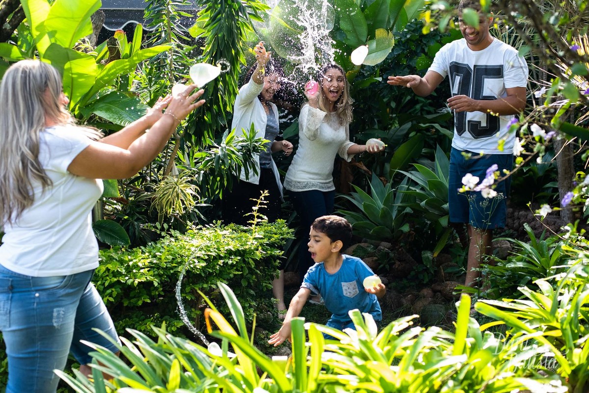 familia brincando com agua durante ensaio de fotos em casa