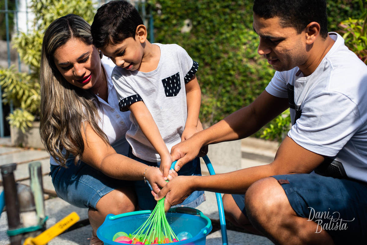 brincadeira com água durante ensaio fotografico de familia em casa