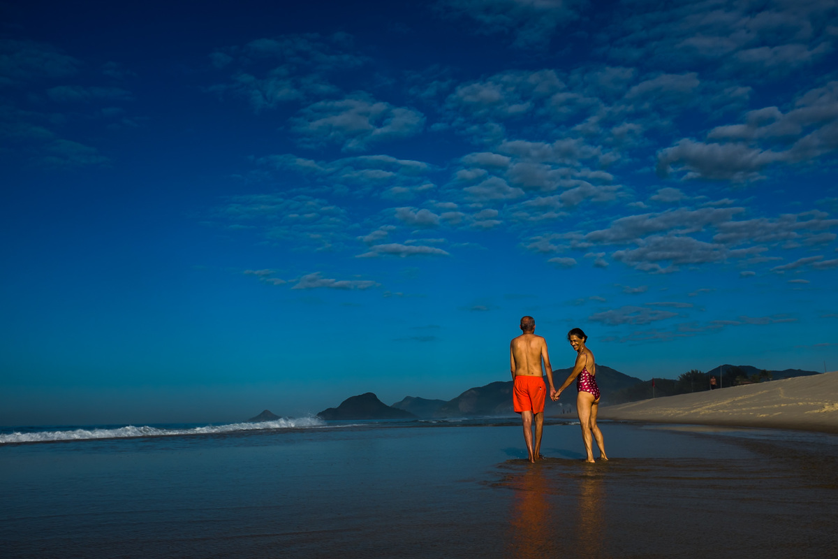 casal caminhando na praia durante ensaio rj