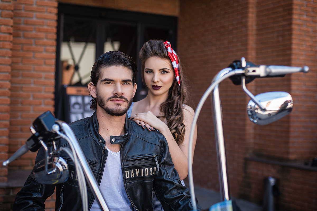 casal pousando para foto em moto da harley davidson