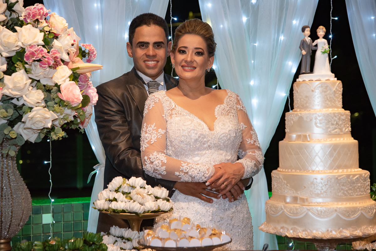 noivos na mesa do bolo