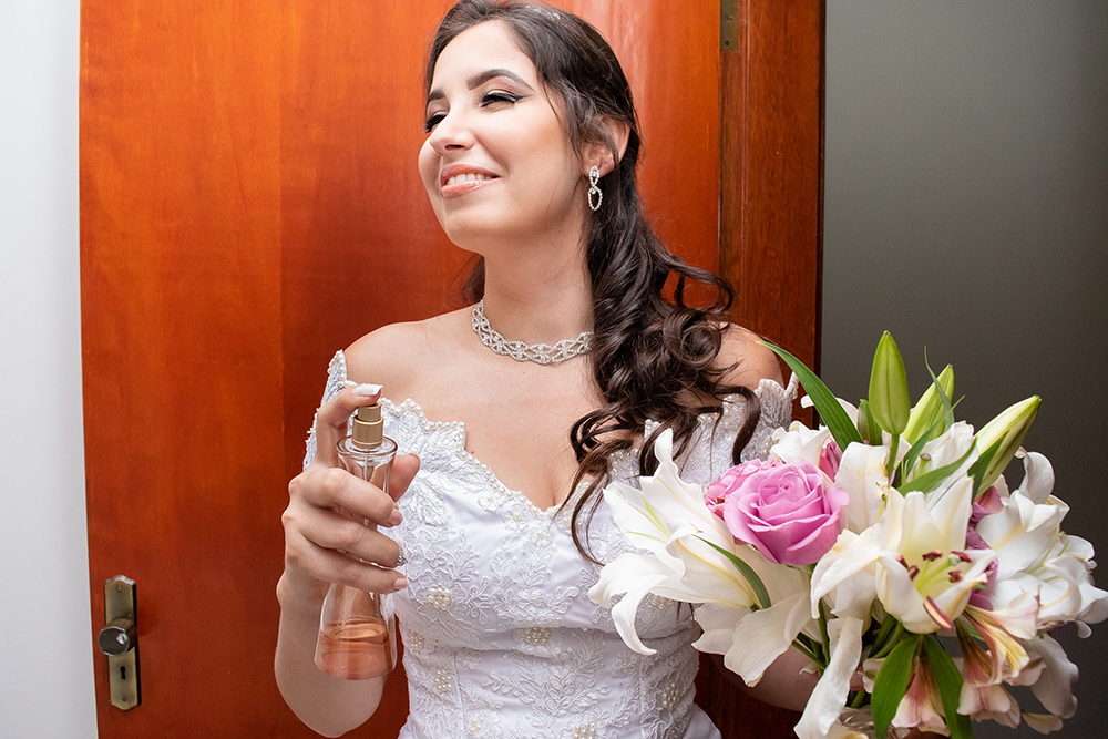 noiva segurando buque e passando perfume