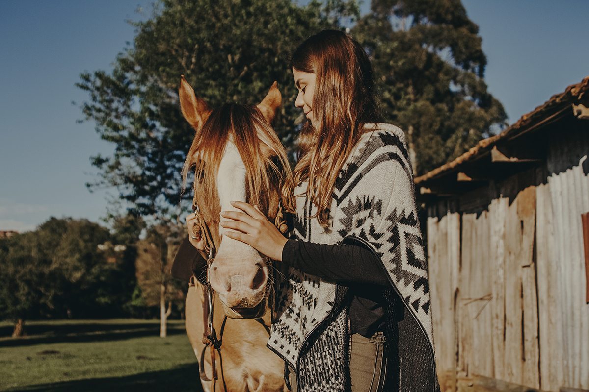 Menina acaricia seu cavalo em ensaio fotográfico