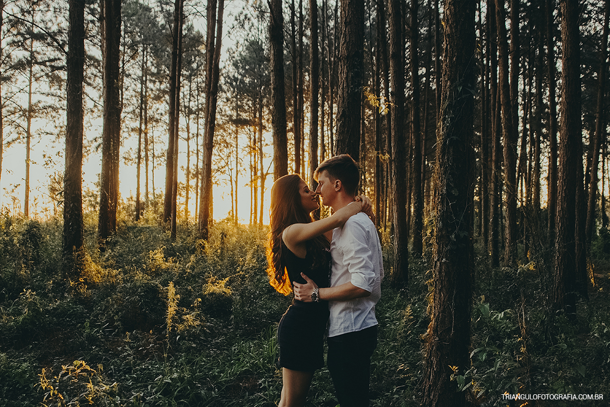 Noivos em pré-wedding fazendo ensaio fotográfico ao por do sol
