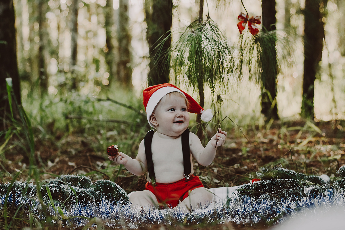 Bebê com roupa de Natal sentado