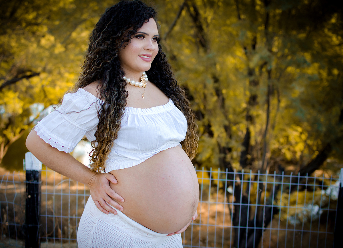 mãe com a mão na cintura no dia do ensaio de gestante 