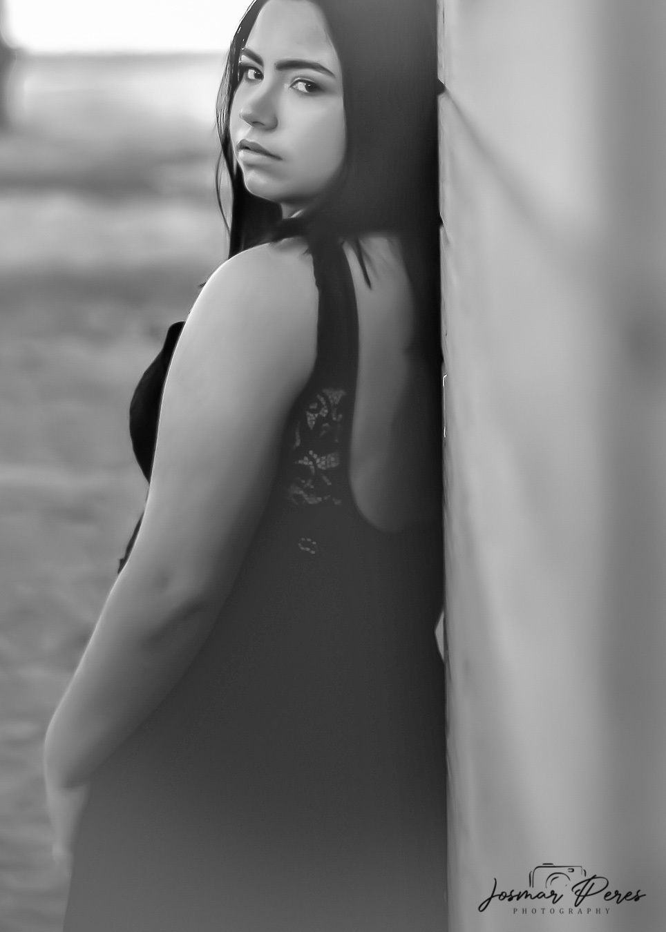 Mulher escorada de costas em casa de madeira