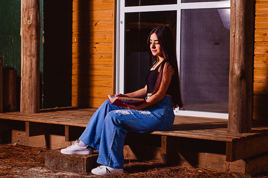 Menina lendo a bíblia na varanda