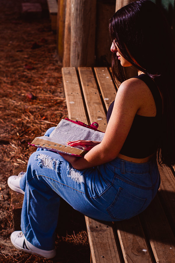 menina sentada lendo a bíblia 