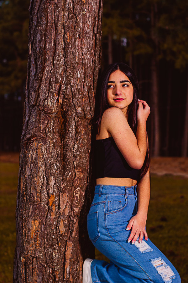menina encostada em árvore para foto de 15 anos