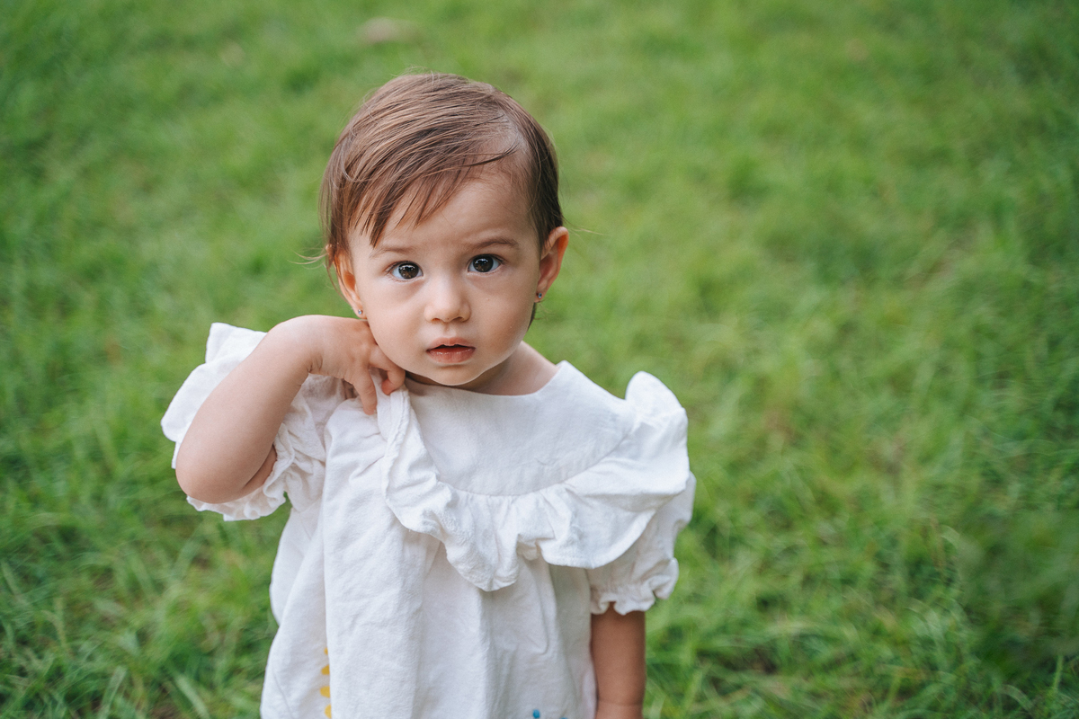Fotógrafa ES registra ensaio de aniversário de 1 ano ao ar livre em Vila Velha. Fotografia de família lifestyle com piquenique, conexão, carinho e momentos espontâneos. Ensaio infantil no Espírito Santo.