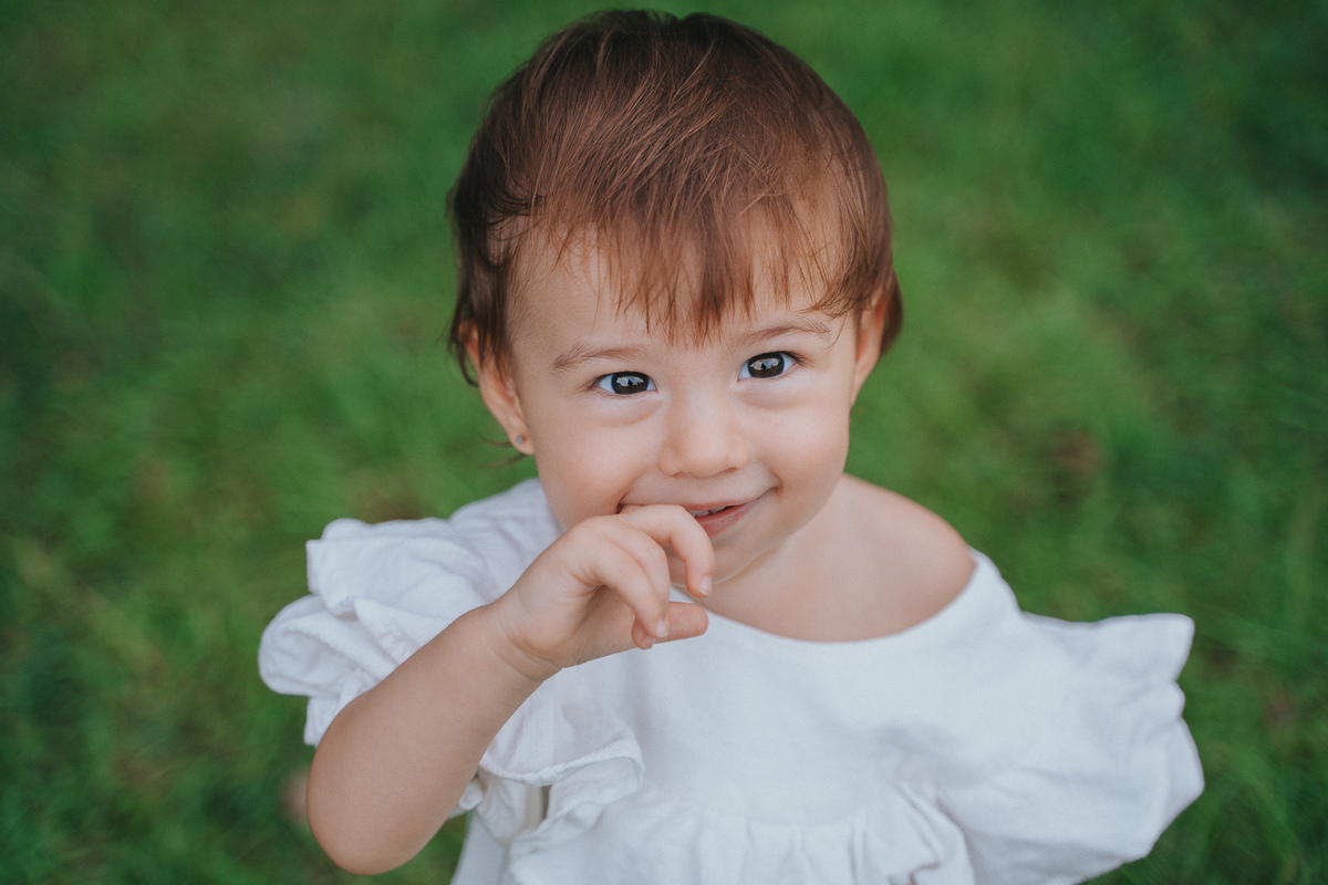Fotógrafa ES registra ensaio de aniversário de 1 ano ao ar livre em Vila Velha. Fotografia de família lifestyle com piquenique, conexão, carinho e momentos espontâneos. Ensaio infantil no Espírito Santo.