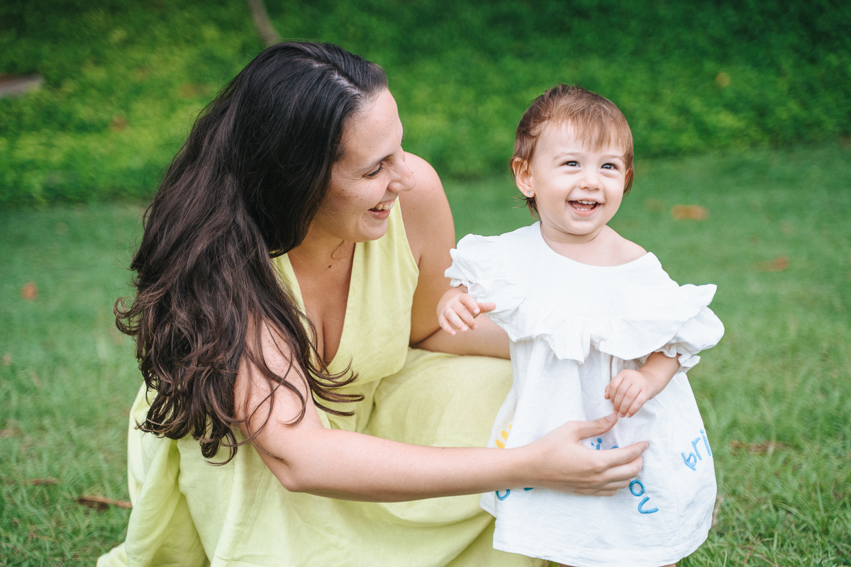 Fotógrafa ES registra ensaio de aniversário de 1 ano ao ar livre em Vila Velha. Fotografia de família lifestyle com piquenique, conexão, carinho e momentos espontâneos. Ensaio infantil no Espírito Santo.