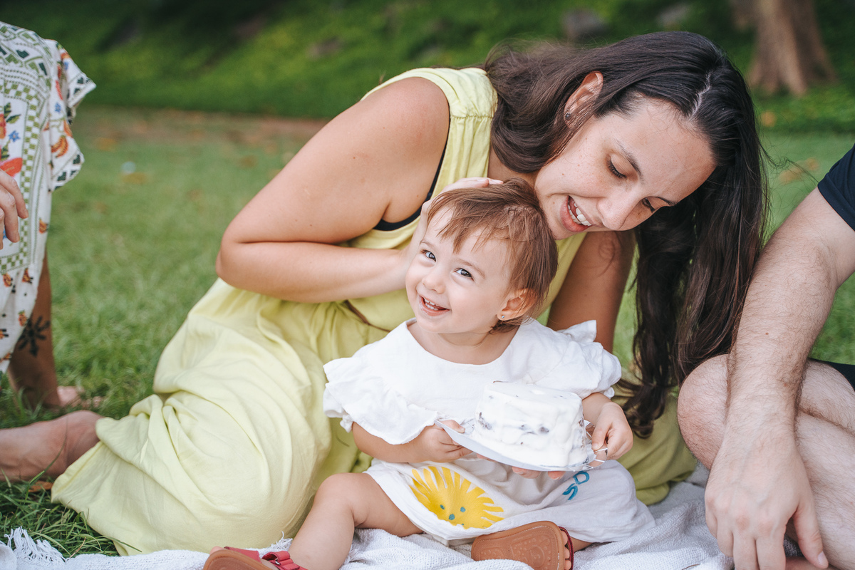 Fotógrafa ES registra ensaio de aniversário de 1 ano ao ar livre em Vila Velha. Fotografia de família lifestyle com piquenique, conexão, carinho e momentos espontâneos. Ensaio infantil no Espírito Santo.