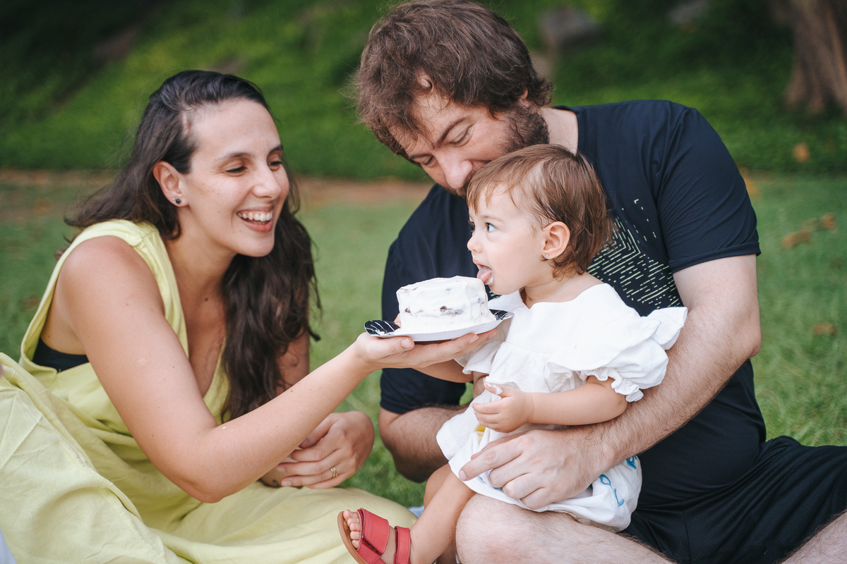 Fotógrafa ES registra ensaio de aniversário de 1 ano ao ar livre em Vila Velha. Fotografia de família lifestyle com piquenique, conexão, carinho e momentos espontâneos. Ensaio infantil no Espírito Santo.