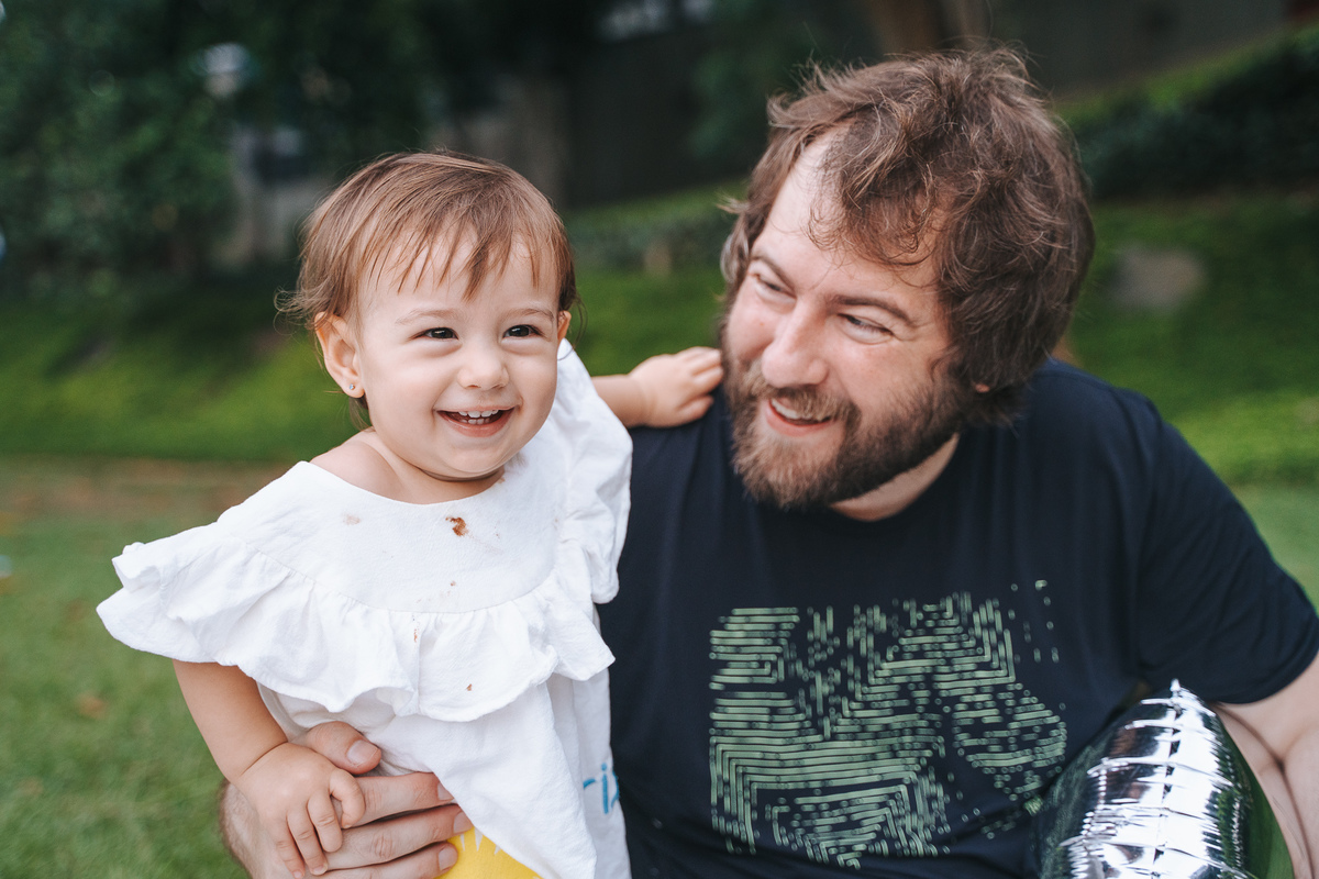Fotógrafa ES registra ensaio de aniversário de 1 ano ao ar livre em Vila Velha. Fotografia de família lifestyle com piquenique, conexão, carinho e momentos espontâneos. Ensaio infantil no Espírito Santo.