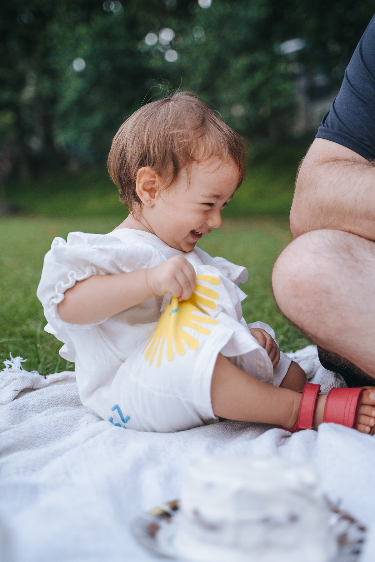 Fotógrafa ES registra ensaio de aniversário de 1 ano ao ar livre em Vila Velha. Fotografia de família lifestyle com piquenique, conexão, carinho e momentos espontâneos. Ensaio infantil no Espírito Santo.