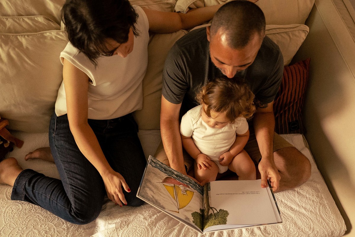 Criança ouvindo histórias com os pais ensaio fotográfico em familia