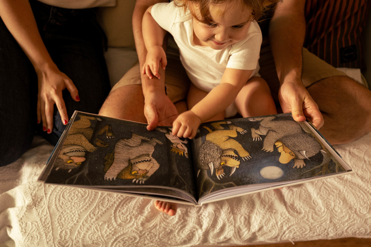 Criança ouvindo histórias com os pais ensaio fotográfico em familia