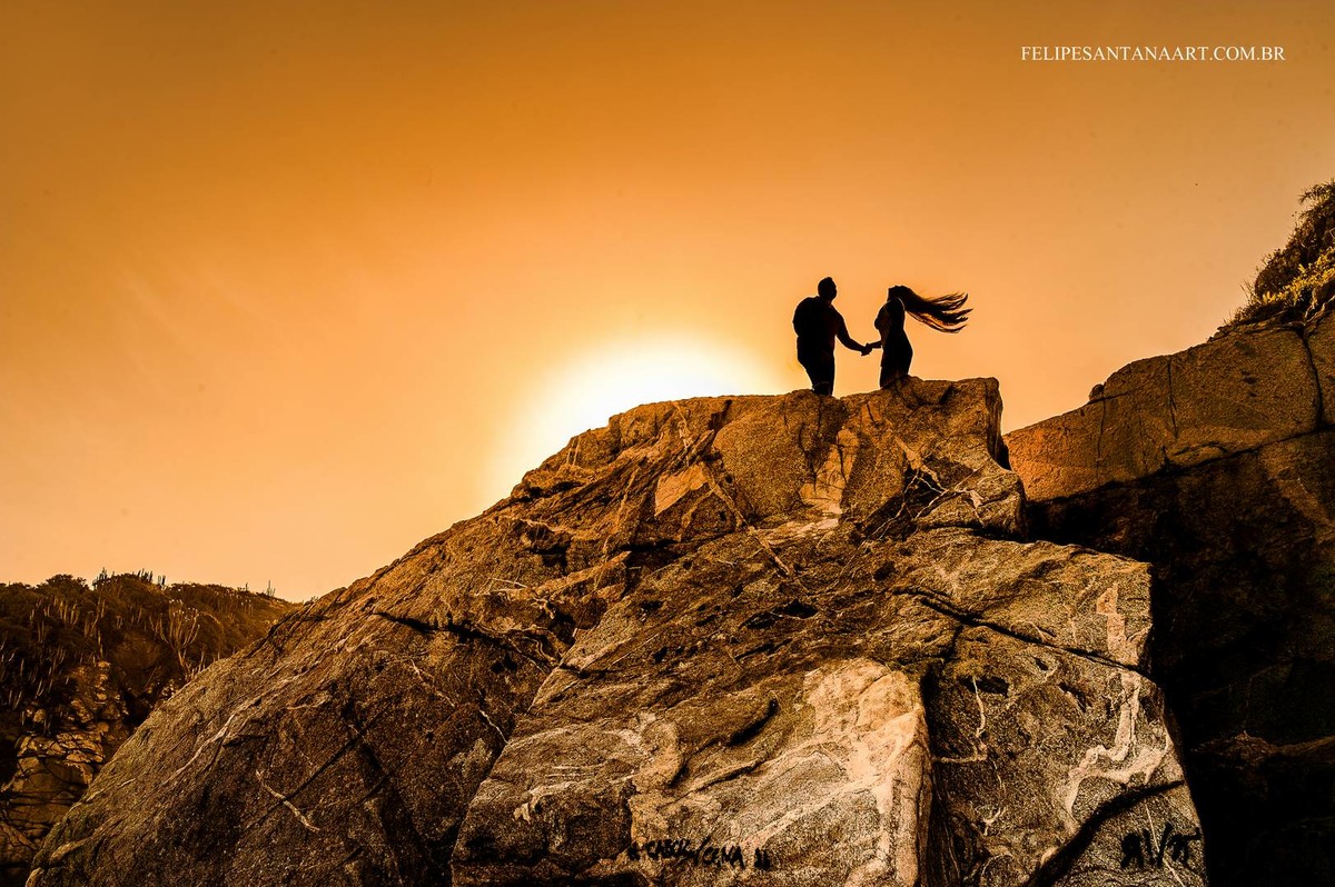 fotografia silhueta por do sol em um lugar alto e distante, casal apaixonados se divertindo muito.