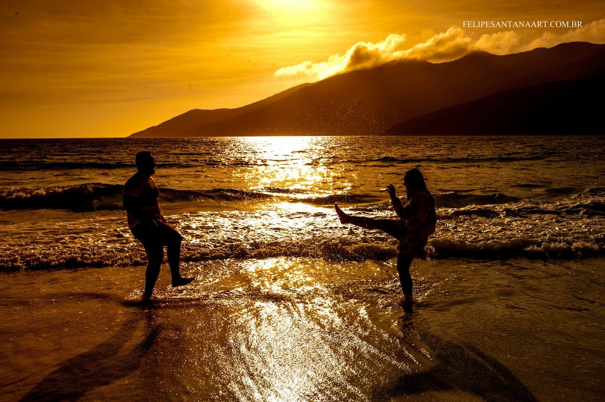 Fotografia feita pelo fotografo de Casamentos Felipe Santana, fotografo de Cataguases, fotografada em Cabo Frio- RJ, fotografia de casal na praia brincando com o pôr do sol maravilho