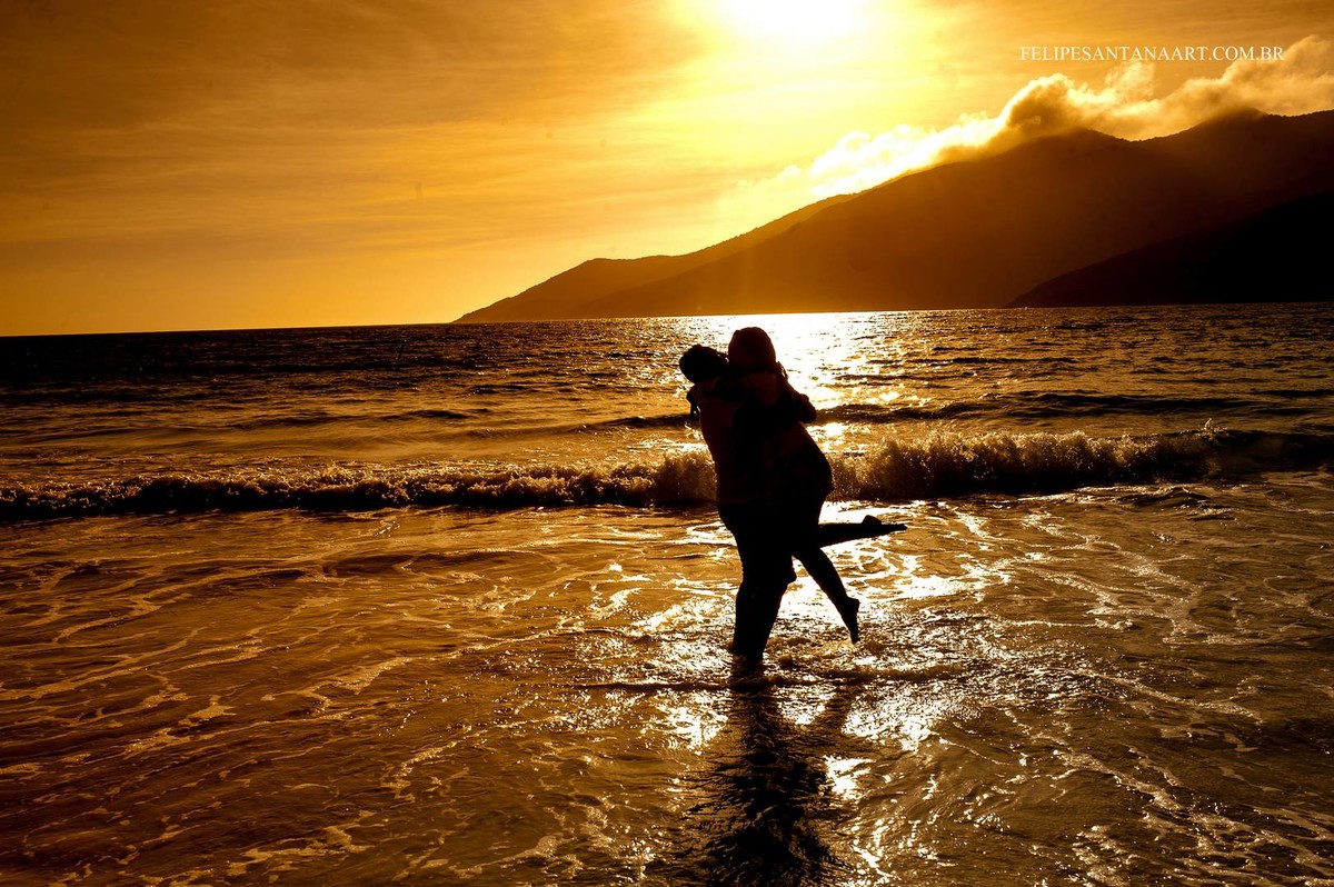 Jovem casal brincando e se divertindo na praia no Brasil em Rio de Janeiro.