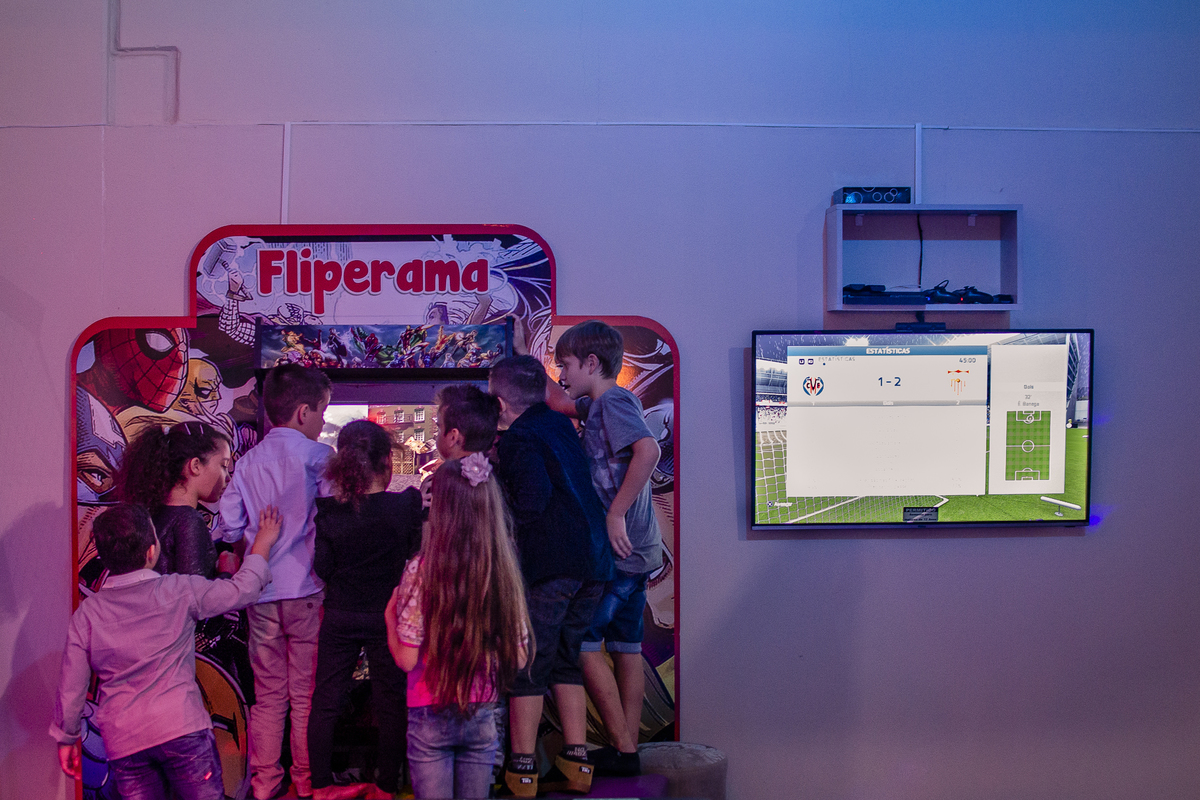 crianças jogando fliperama