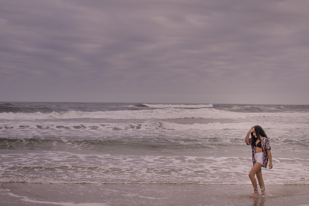 menina caminhando na beira da praia