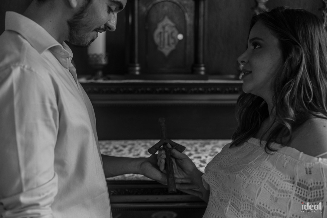 casal segurando cruz em ensaio de gestante