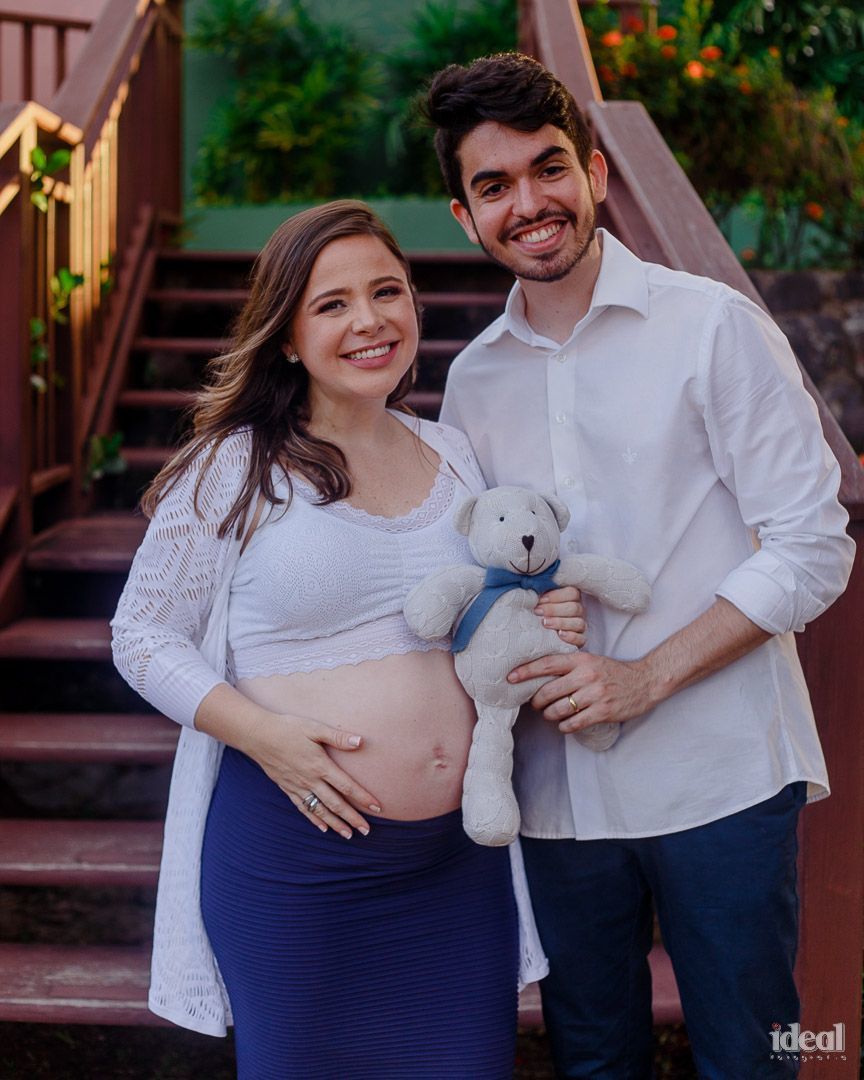 casal segurando a barriga em book de fotos gestante