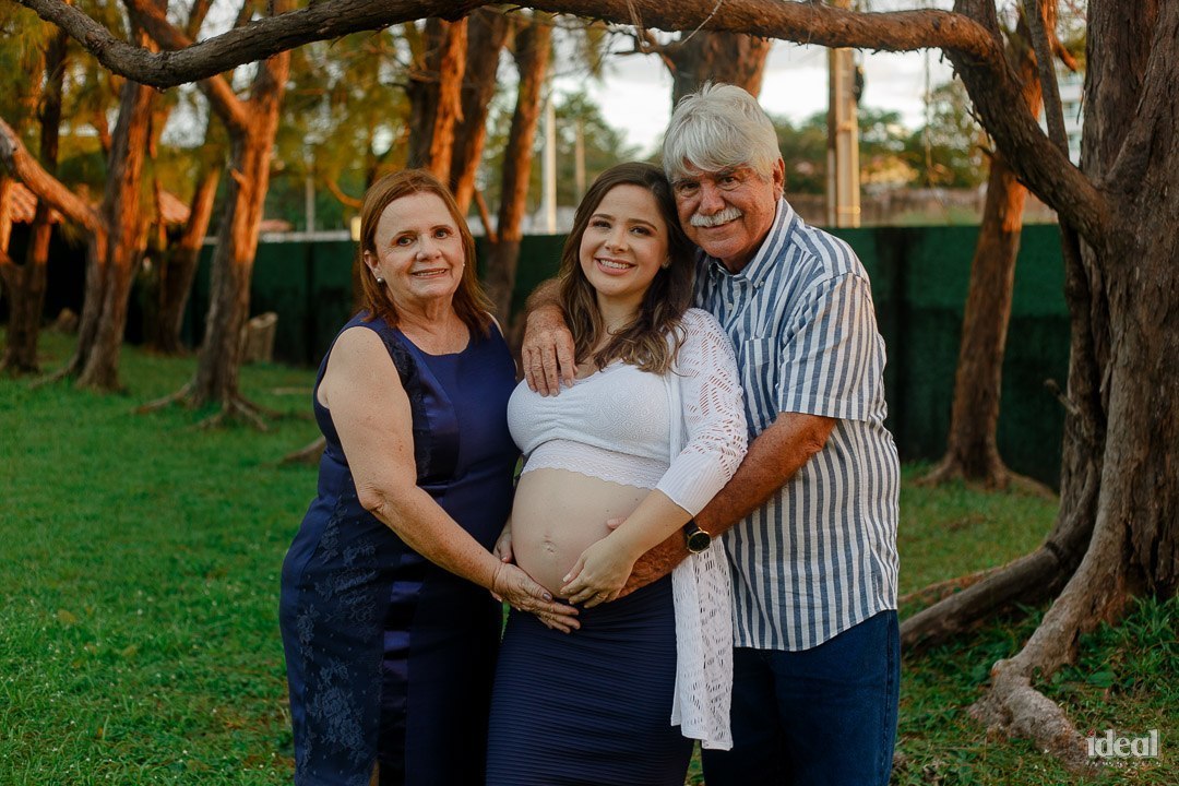 pais abraçando a filha em seu primeiro ensaio gestante