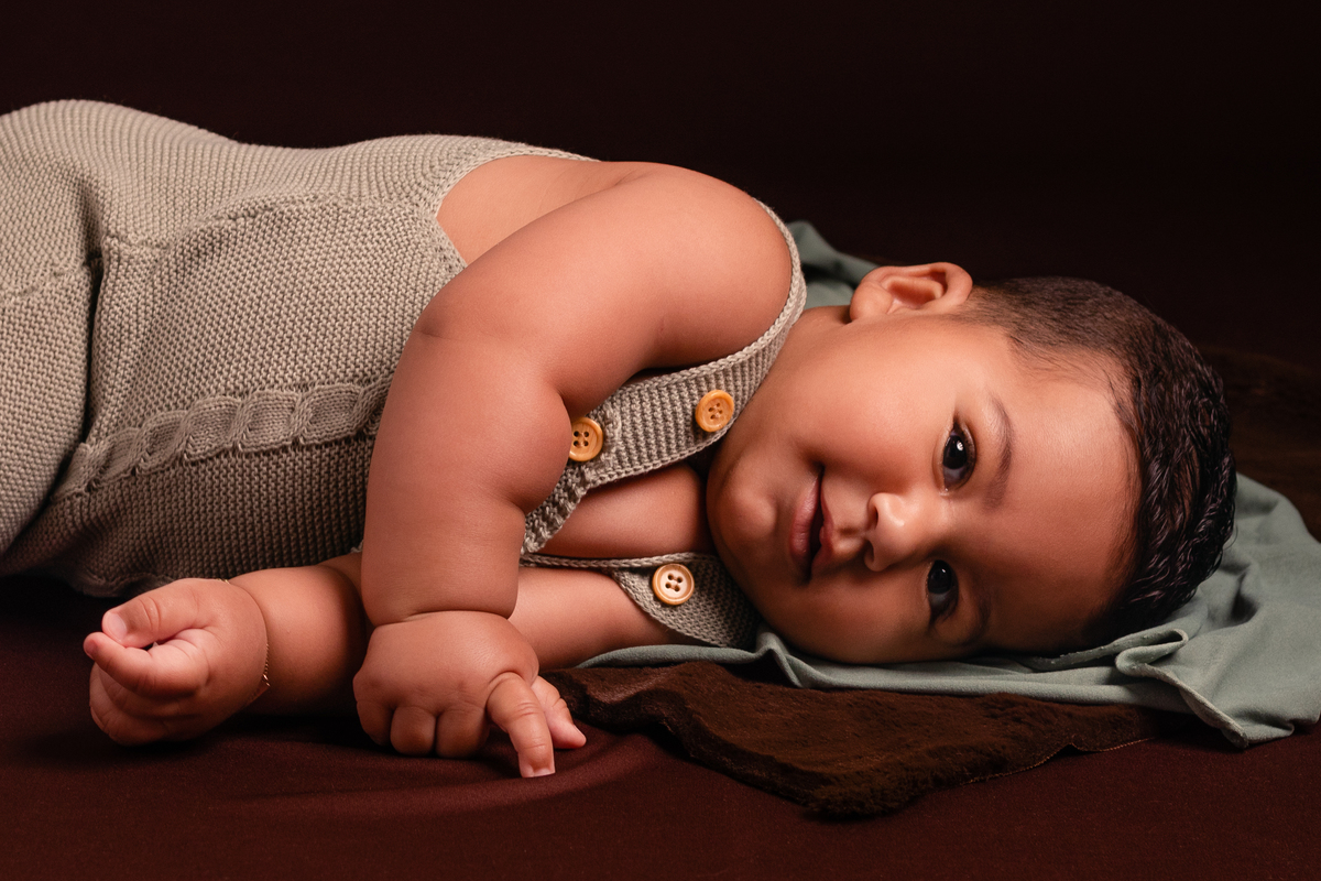 Bebê fofo deitado, sorrindo no seu ensaio de acompanhamento de 6 meses no Ander Lopes Fotografia em Taquara/RS