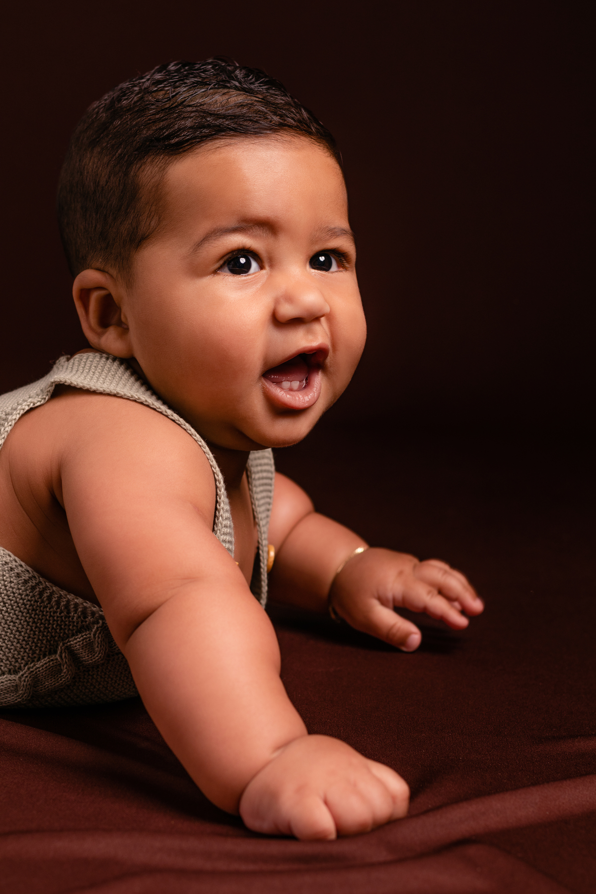 Bebê fofo em close, sorrindo no seu ensaio de acompanhamento de 6 meses no Ander Lopes Fotografia em Taquara/RS