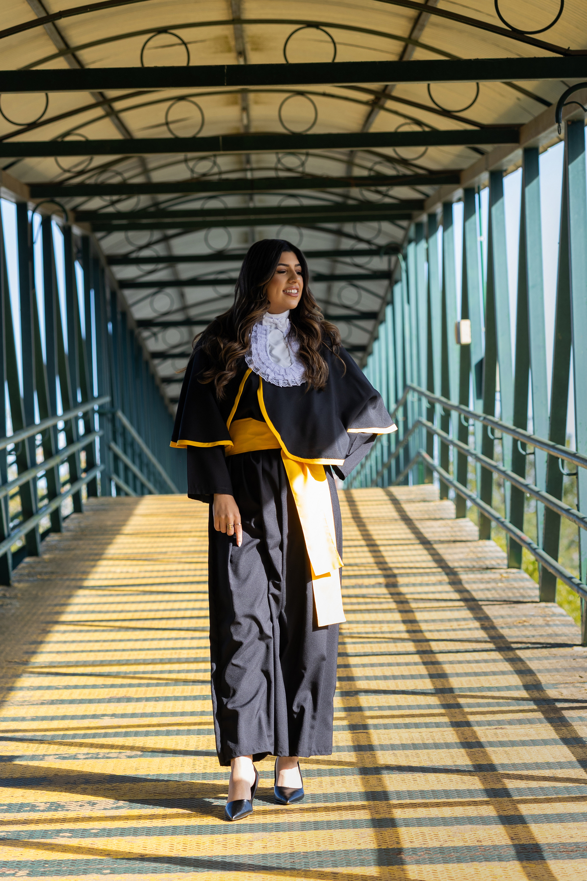 Laura, formanda em Farmácia, durante ensaio de prova de toga em ambiente externo.