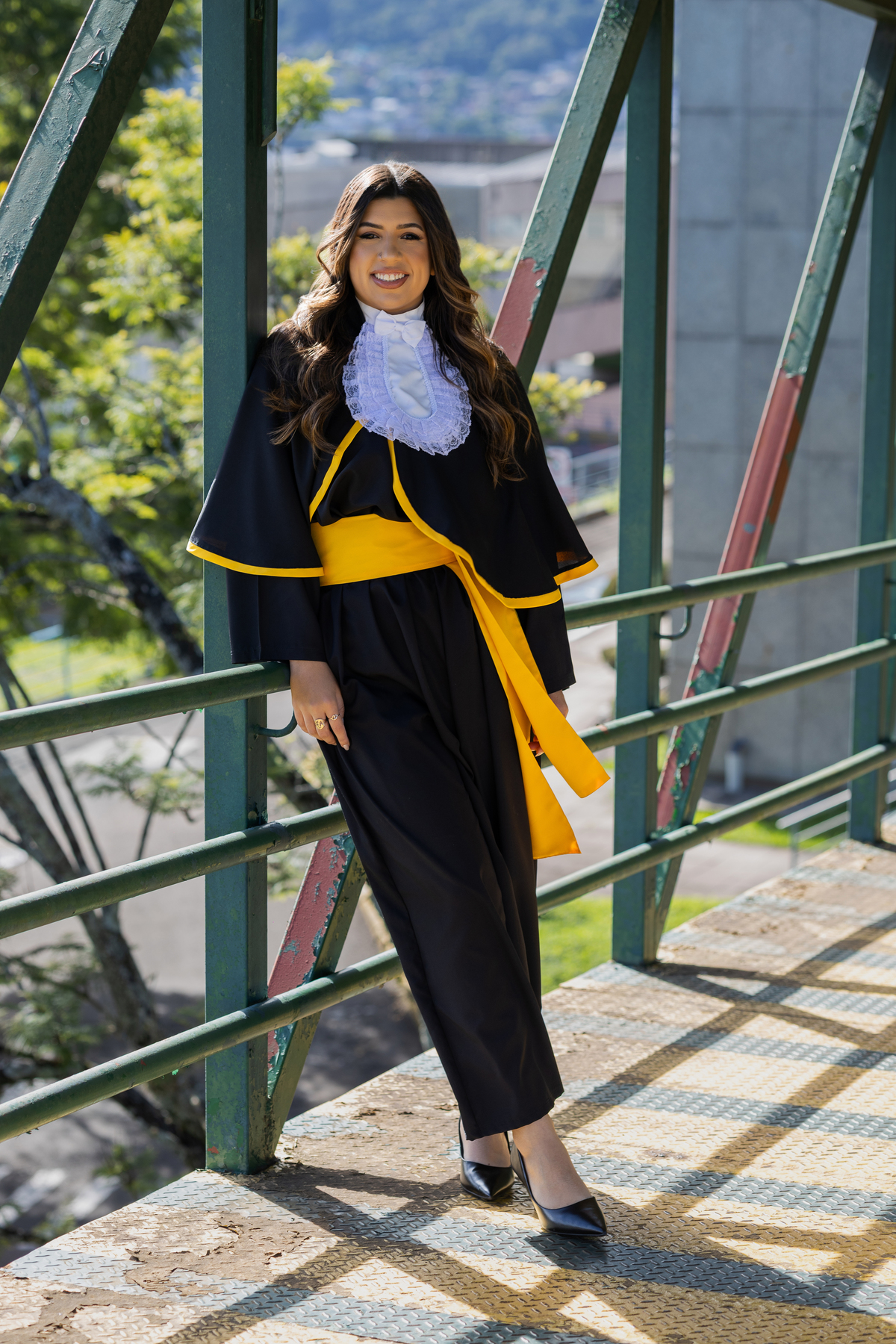 Laura, formanda em Farmácia, durante ensaio de prova de toga em ambiente externo.