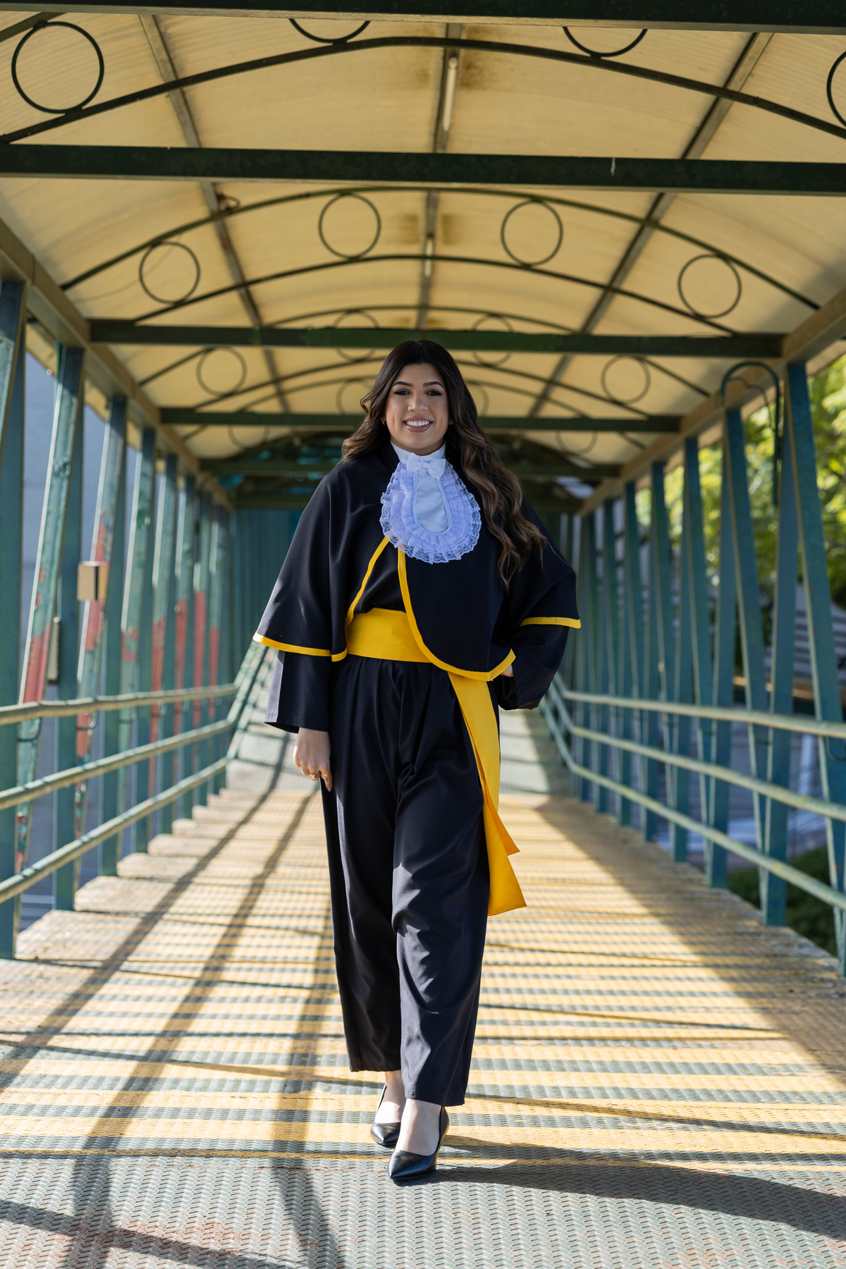 Laura, formanda em Farmácia, durante ensaio de prova de toga em ambiente externo.