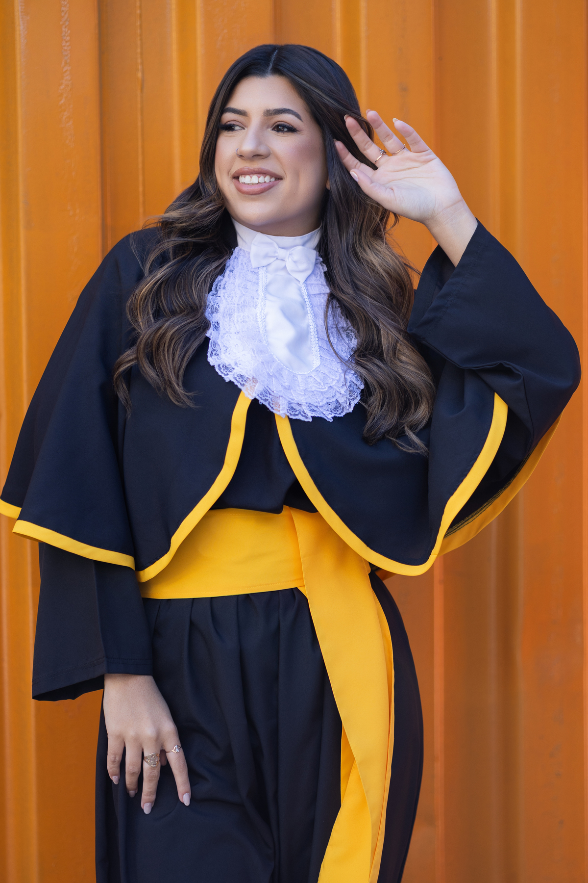 Laura, formanda em Farmácia, durante ensaio de prova de toga em ambiente externo.