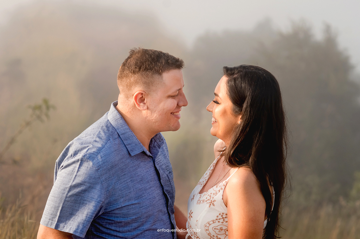 Foto casal de frente um para o outro sorrindo
