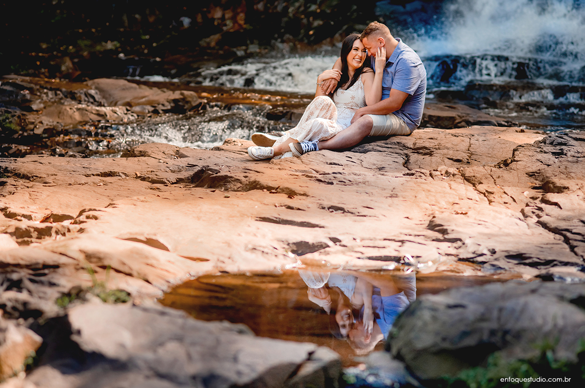 Foto casal sentado nas pedras do rio em Brotas