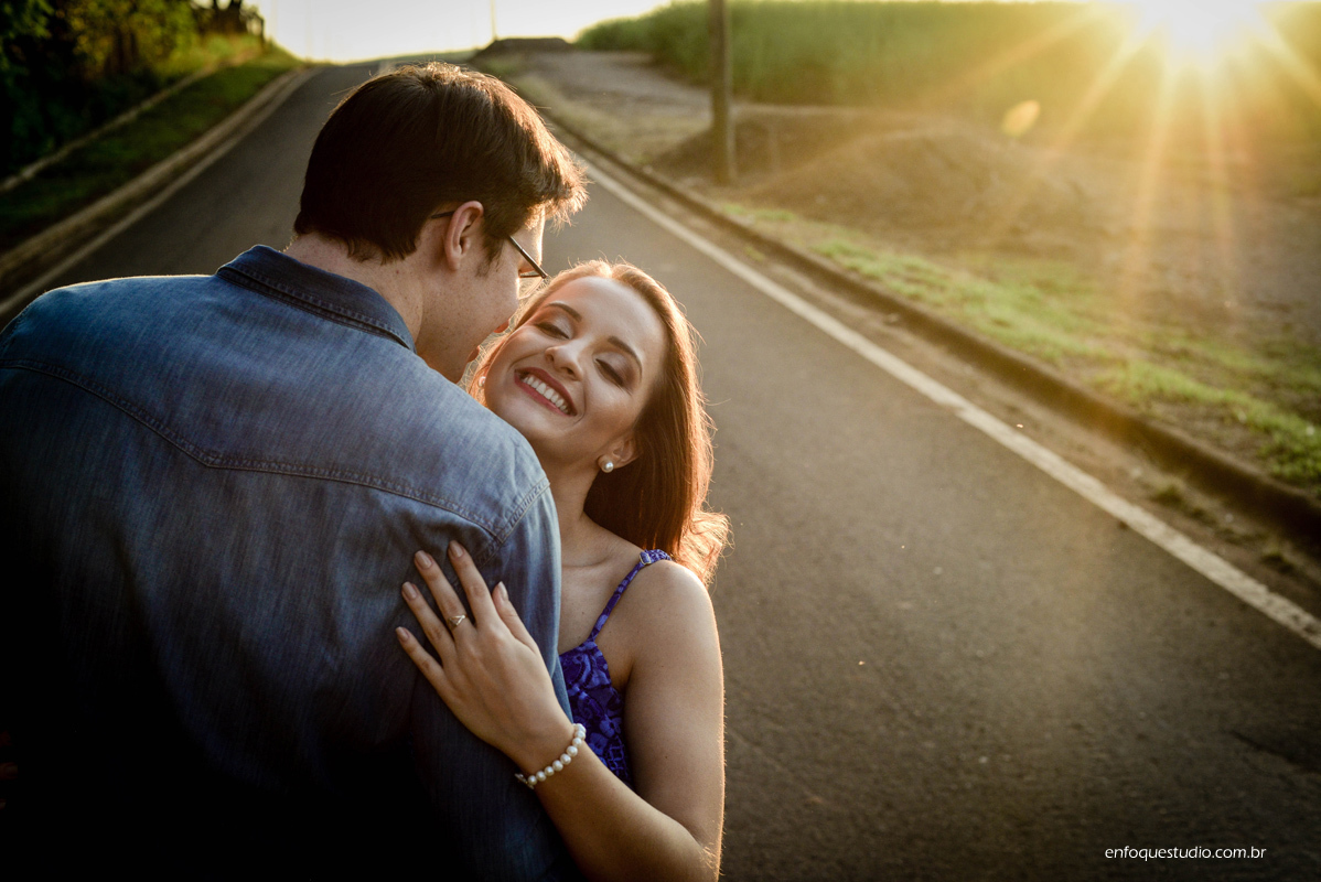 Foto espontânea da noiva sorrindo com o noivo e sol entrando