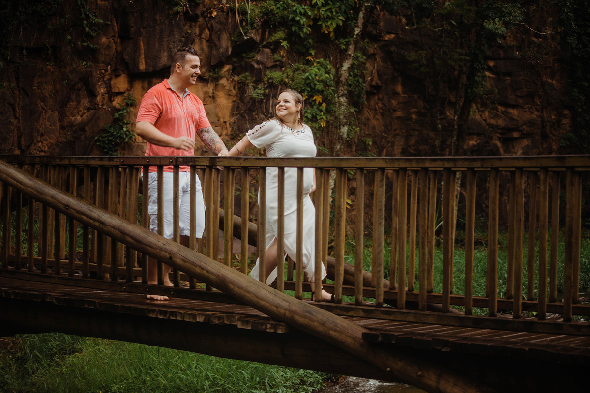 Foto de casal correndo na ponte e com chuva