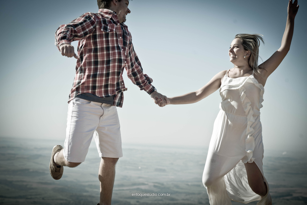 Foto de casal saltando na serra de são pedro