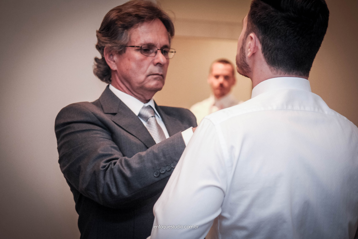 Pai colocando gravata em noivo