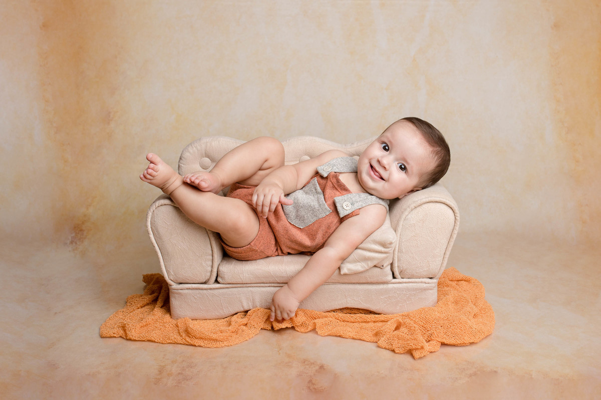 foto acompanhamento bebe deitado no sofá com as pernas pra cima