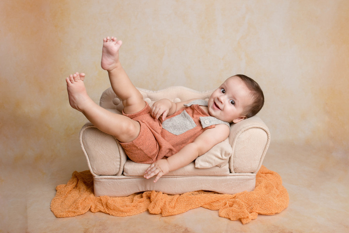 foto acompanhamento bebe deitado no sofá com as pernas pra cima