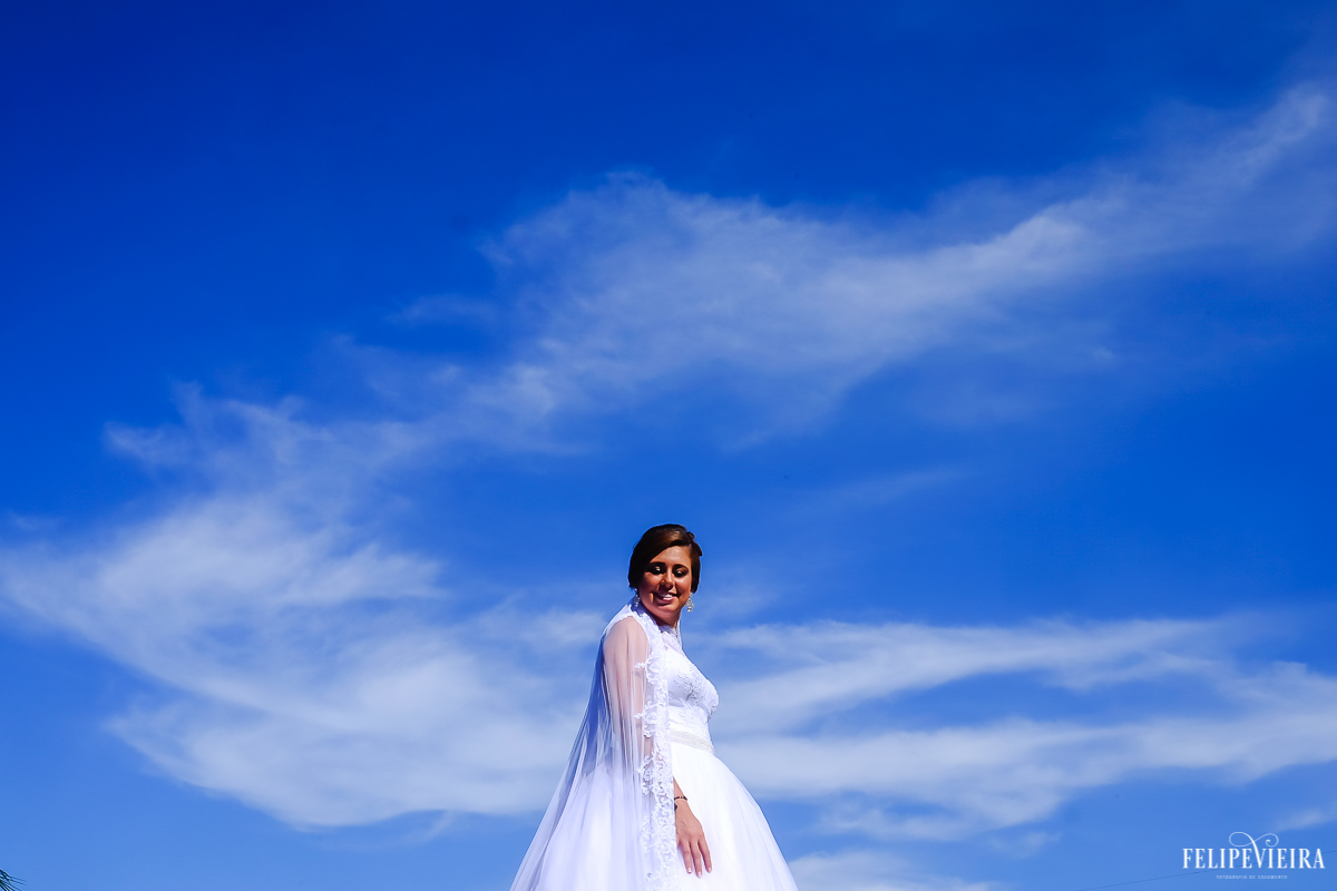 noiva exbindo seu indo estido dde noiva durante ensaio pós wedding em um belo dia de céu azul