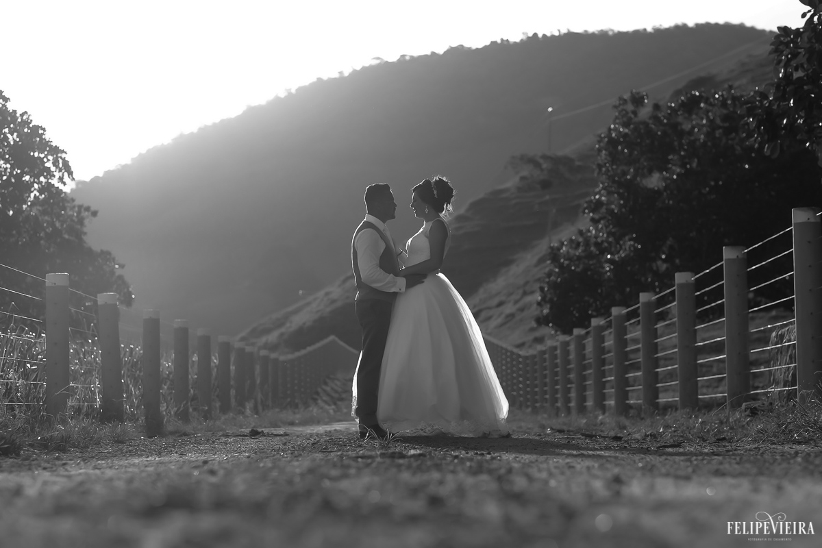 fotografia em preto e branco do casal de noivos numa estradinha de terra em um belo pôr do sol felipe vieira fotografia de casamento em guarapari-es