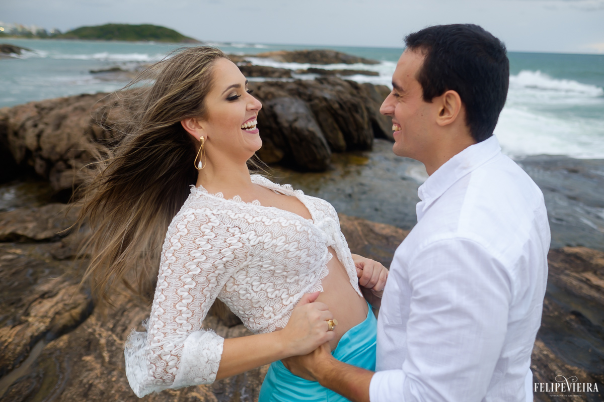 noivo segurando a noiva e a fazendo rir em frente ao mar Guarapari, foto feita por Felipe Vieira fotógrafo de casamentos.
